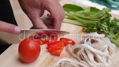 男人`露天厨房里切蔬菜和青菜. 女人用刀子做饭。 一步一步